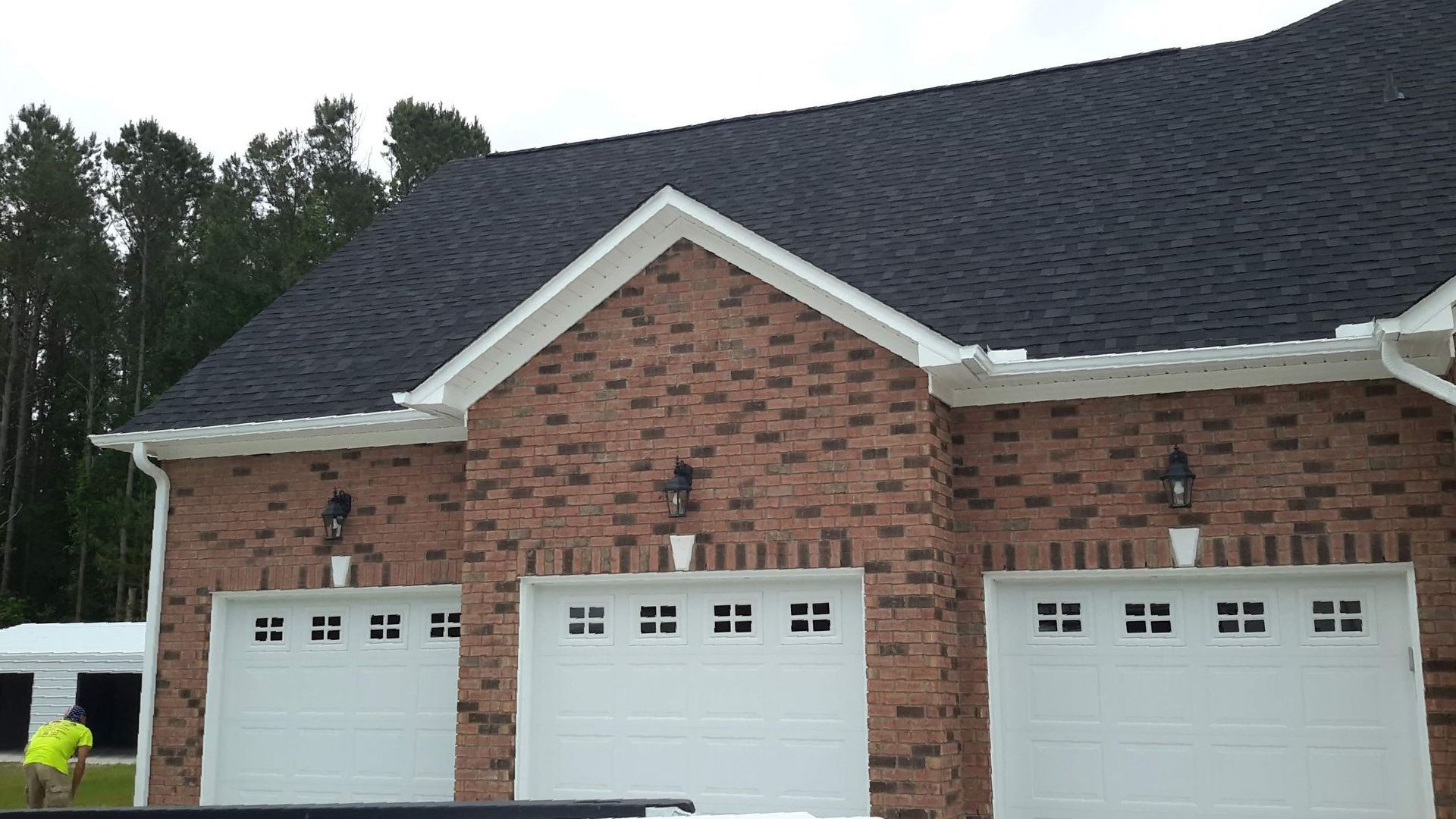 Light beige mobile home with multiple windows, a sliding glass door, and decorative rock base, set against a blue sky.