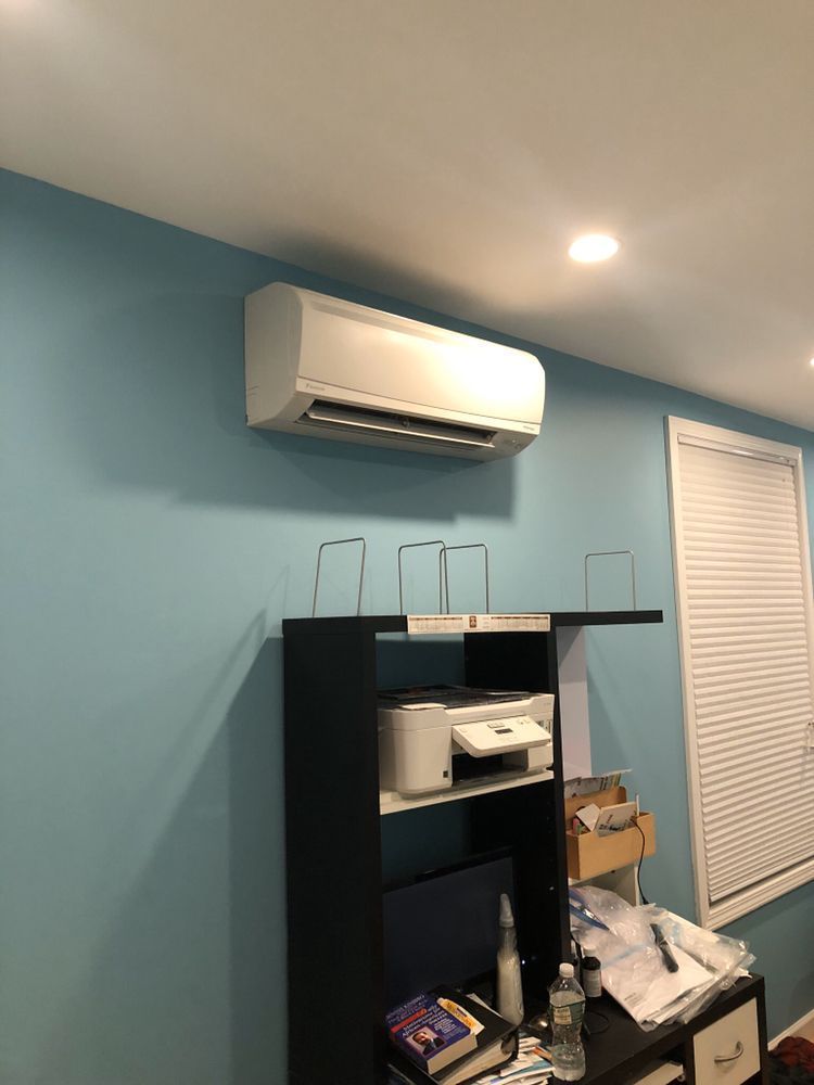 a room with blue walls and a white air conditioner hanging from the ceiling .