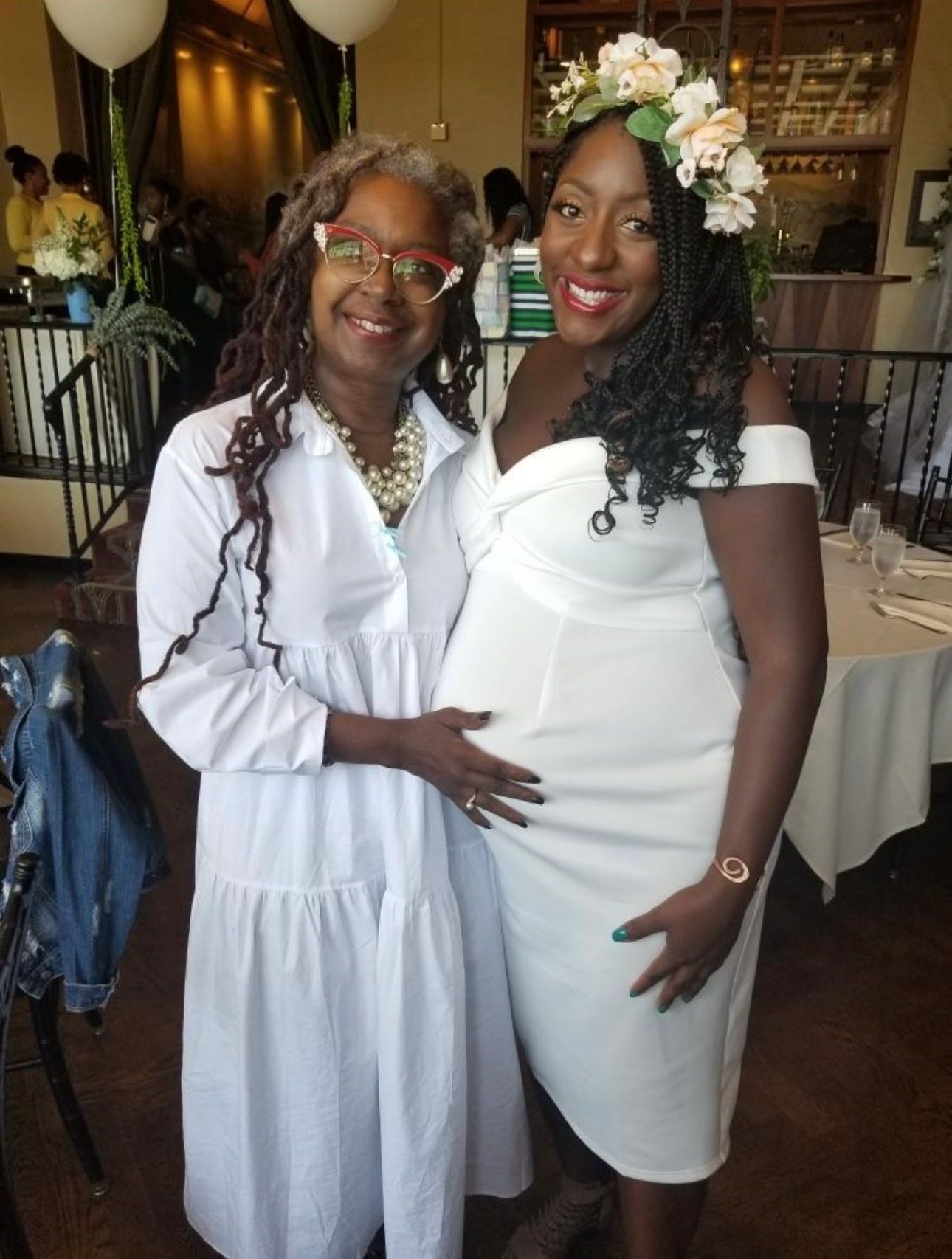 Woman in a White Dress is Hugging a Pregnant Woman