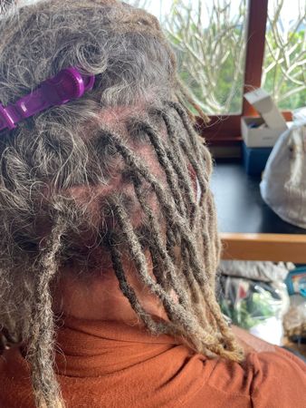 close up of dreadlock maintenance, dread sections, grey thin dreads