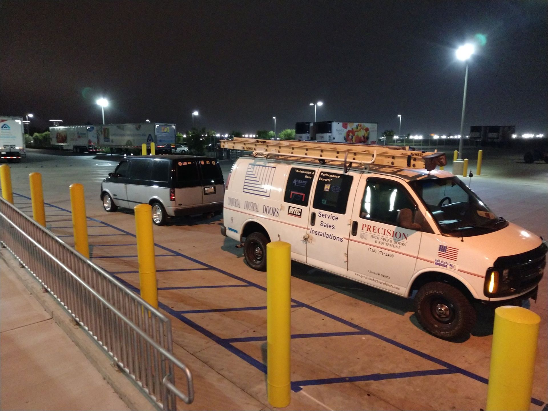 A white van with a ladder on top is parked in a parking lot