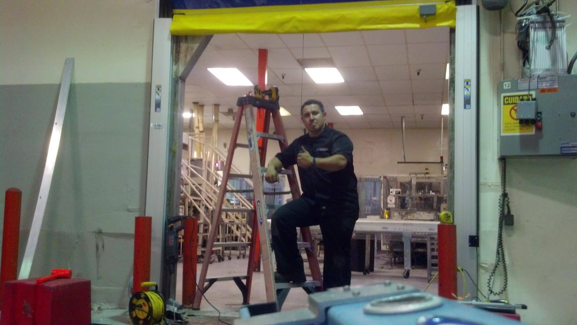 A man is sitting on a ladder in front of a door.