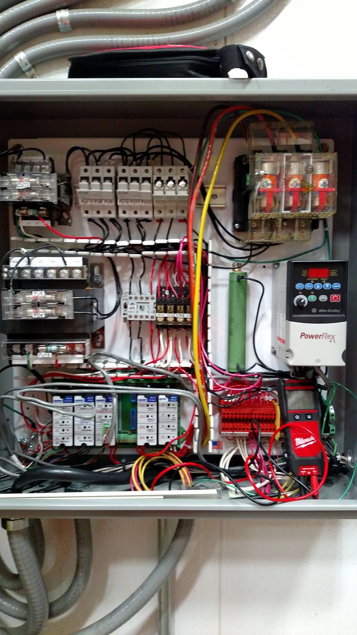 The inside of a electrical box with a lot of wires coming out of it.