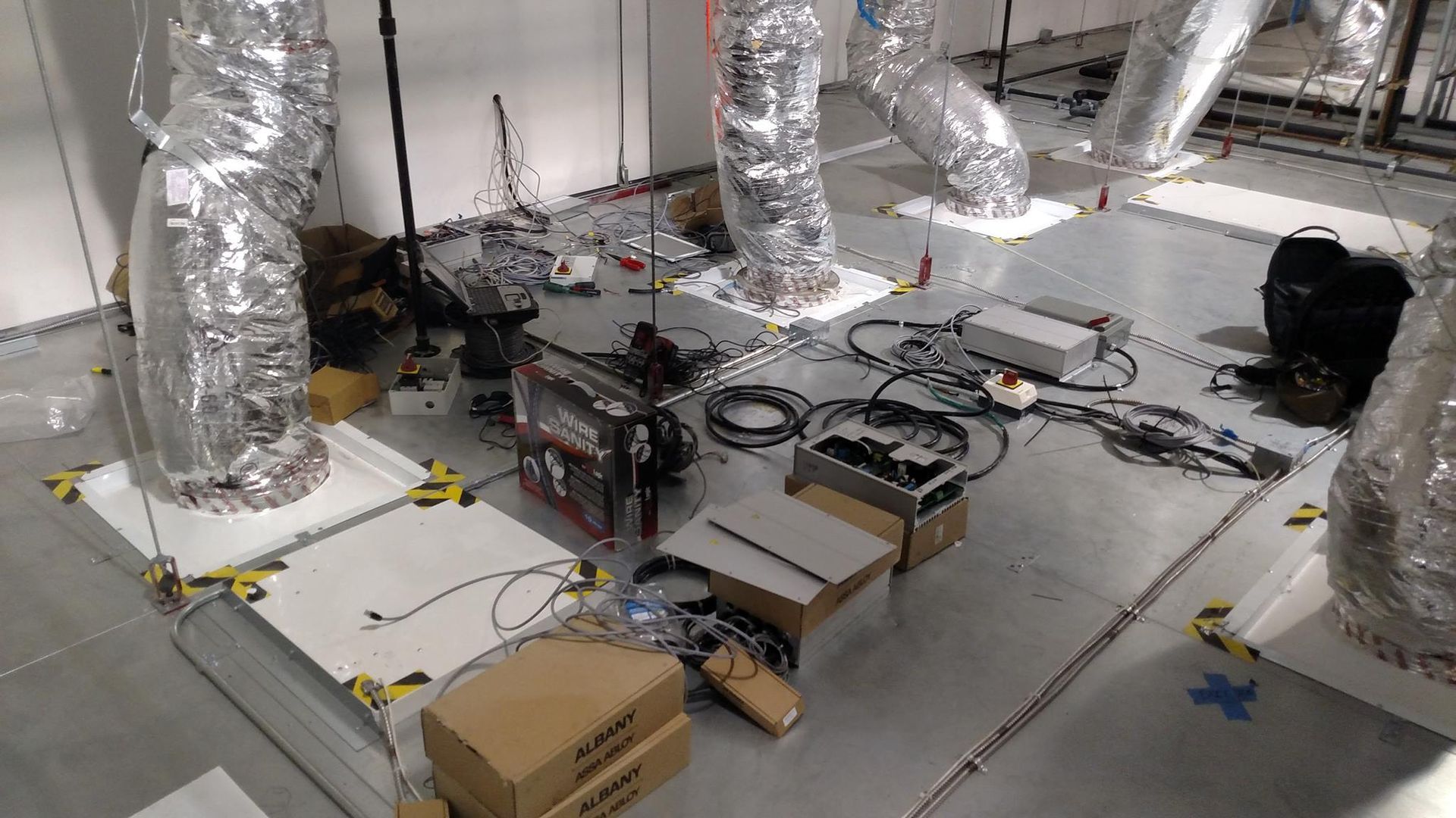 A room with a lot of wires and boxes on the floor.