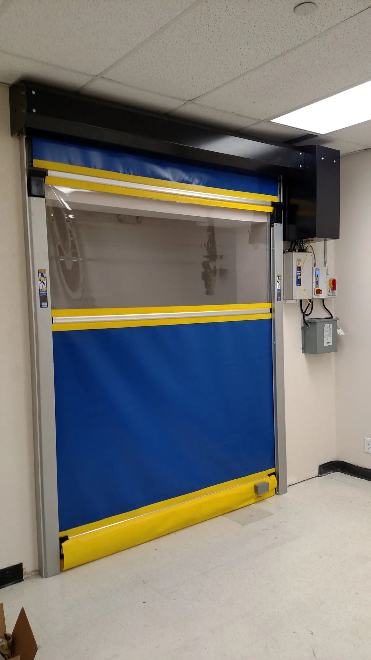 A blue and yellow door is hanging on a wall in a room.