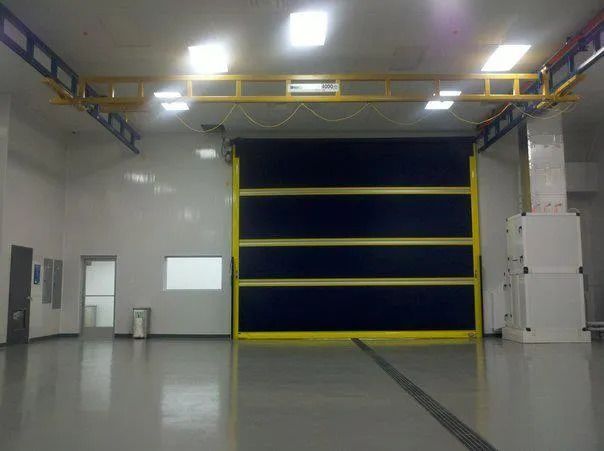 Three orange garage doors on a light-colored building, with a side door and sunlit bricks below.