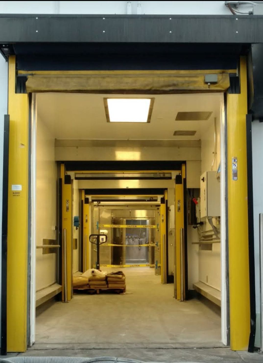 Yellow loading dock entrance with multiple openings receding into a building.