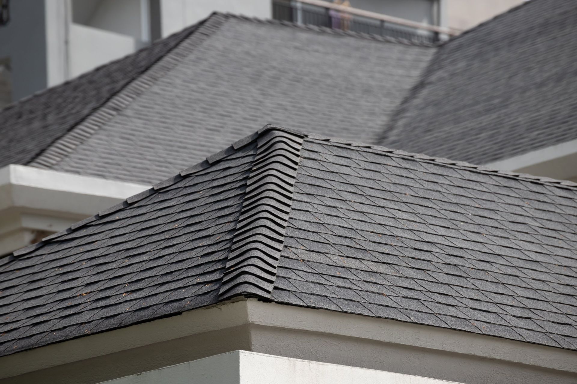 Gray asphalt shingle roof on a building, angled view.