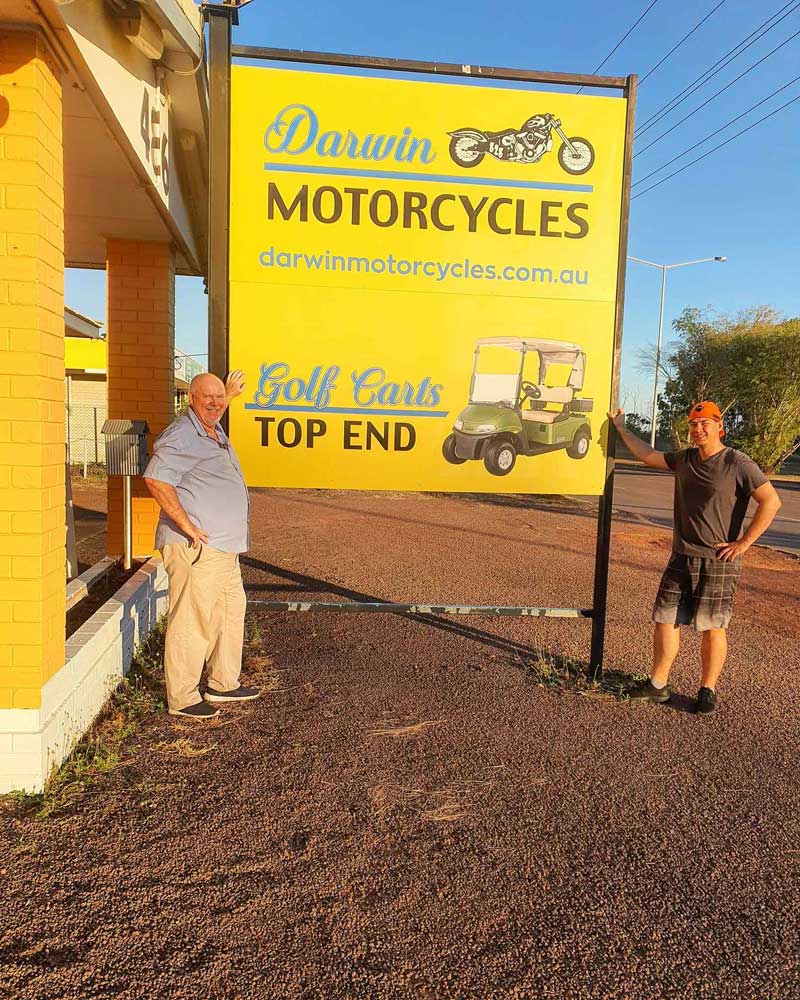 Darwin Motorcycles Huge Signage with Two Man next to it — Darwin Motorcycles in Winnellie, NT