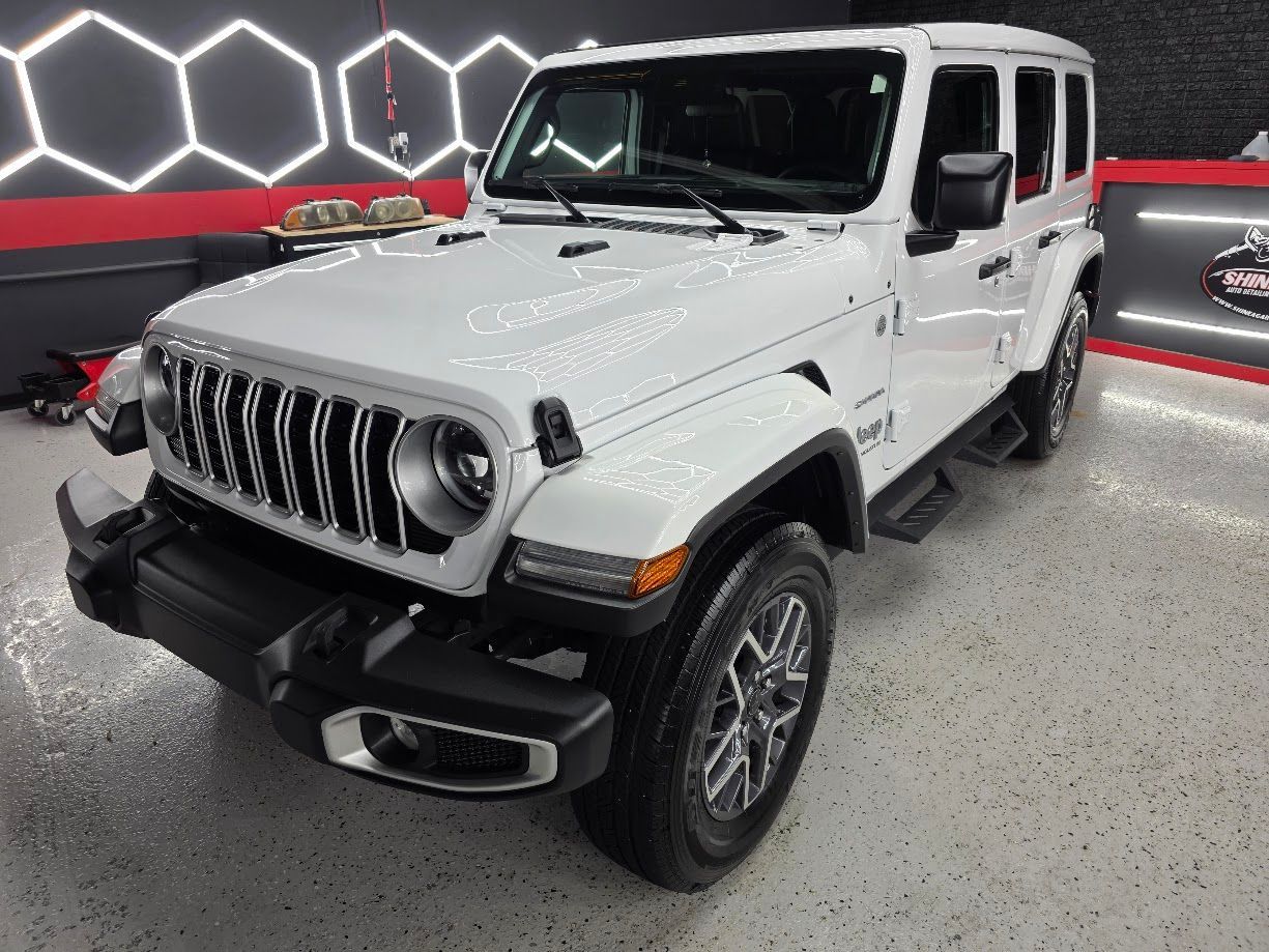 Hydrophobic water beading on a white Jeep Wrangler following a signature ceramic coating application.