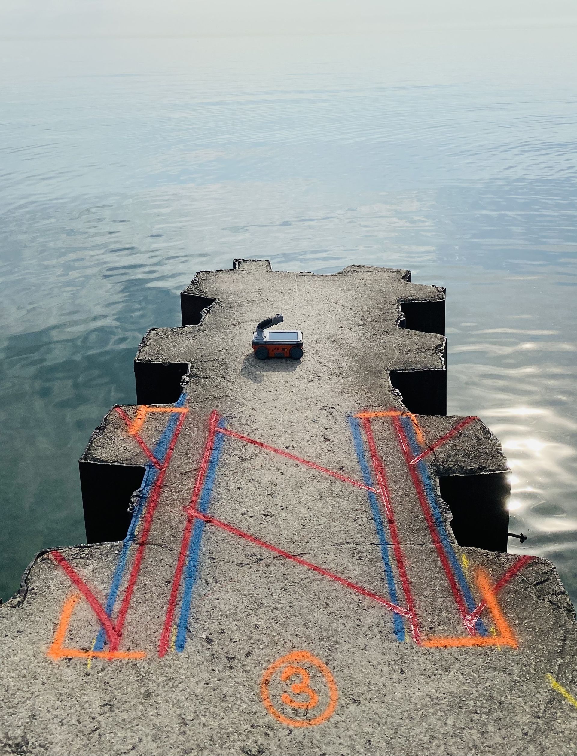 A boat is sitting on a dock next to a body of water.