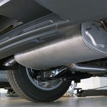 The underside of a car with a stainless steel exhaust pipe