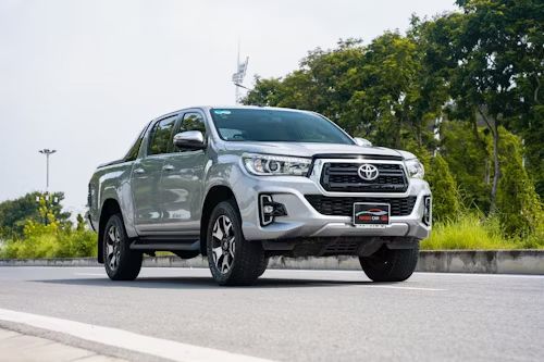 Silver Toyota Hilux pickup truck on a road, driving towards the viewer.