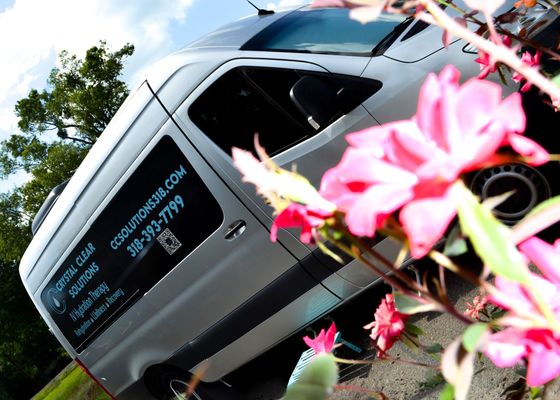 A silver van with flowers in front of it