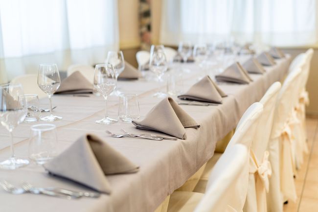 Quattro panettoni realizzati a mano, con guarnizioni diverse, allineati su una superficie metallica.