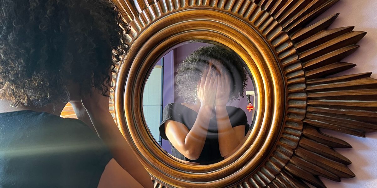 a woman looks in a mirror