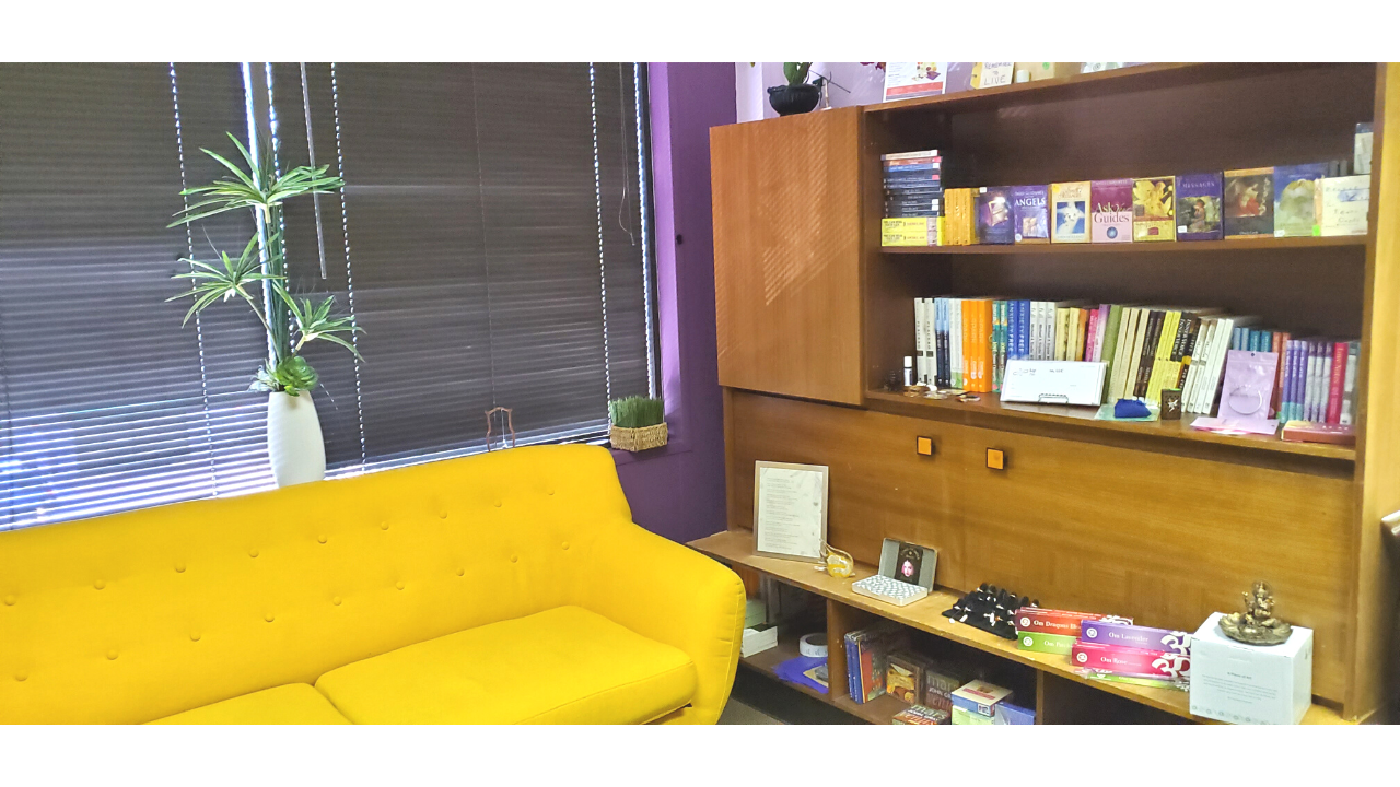 calm office space for spiritual healing with bright sofa and bookcase of self-healing books