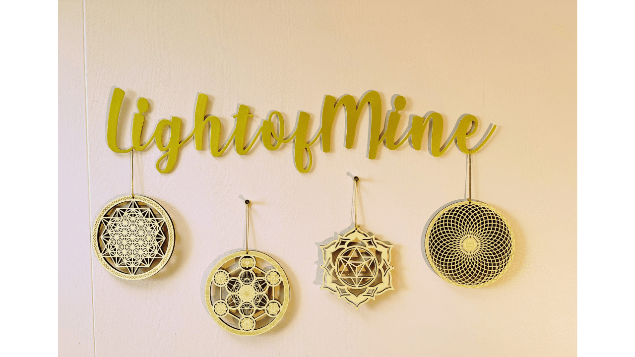 light of mine wall hanging in gold with sacred geometry symbols in spiritual healing office