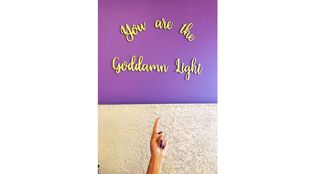 gold mantra lettering for light of mine hanging on the wall