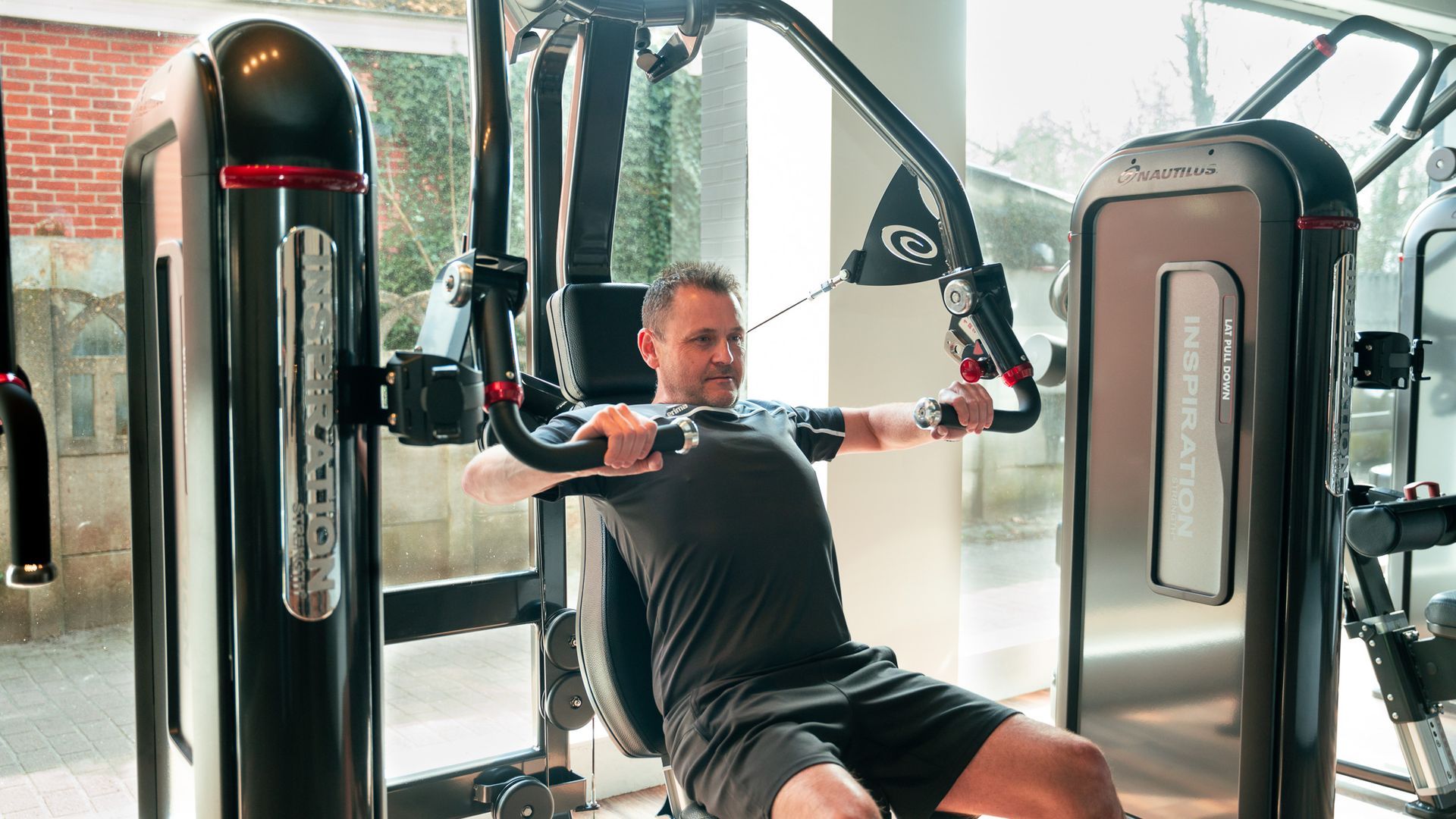 Een man gebruikt een apparaat in een sportschool.