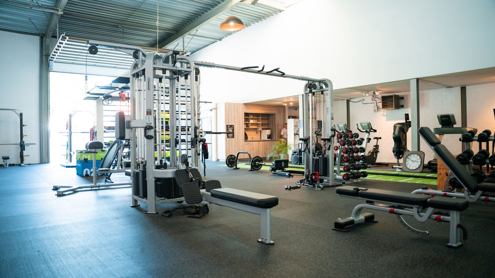 Een grote sportschool vol met fitnessapparatuur.