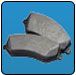 Two grey brake pads on a blue background. | Quality Car & Truck Repair Inc