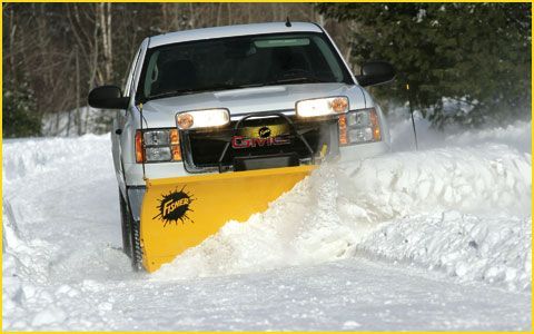 White truck with yellow snowplow clearing snow on a road. | Quality Car & Truck Repair Inc