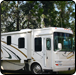 White RV parked in front of trees.  |  Quality Car & Truck Repair Inc