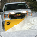Snowplow truck clearing a snowy road with yellow blade.  |  Quality Car & Truck Repair Inc