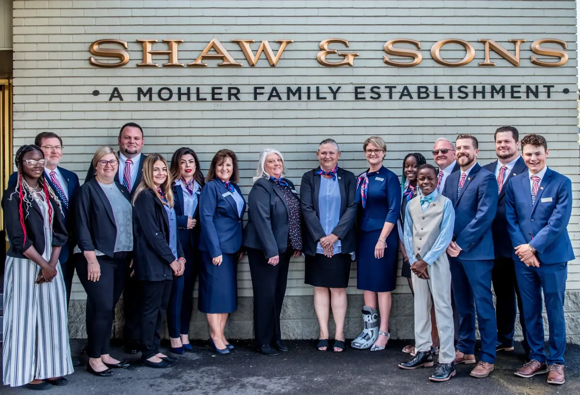 Group of people in front of a building with the name