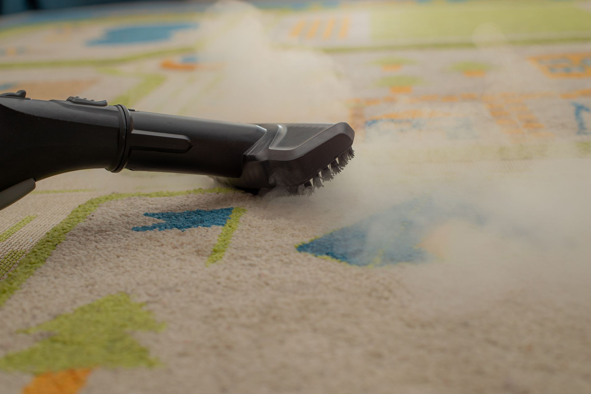 Black vacuum nozzle cleaning colorful carpet fibers close-up