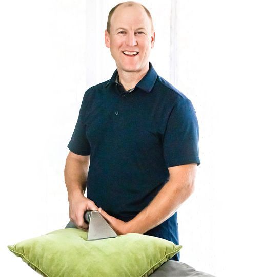 a man in a blue shirt is cleaning a green pillow