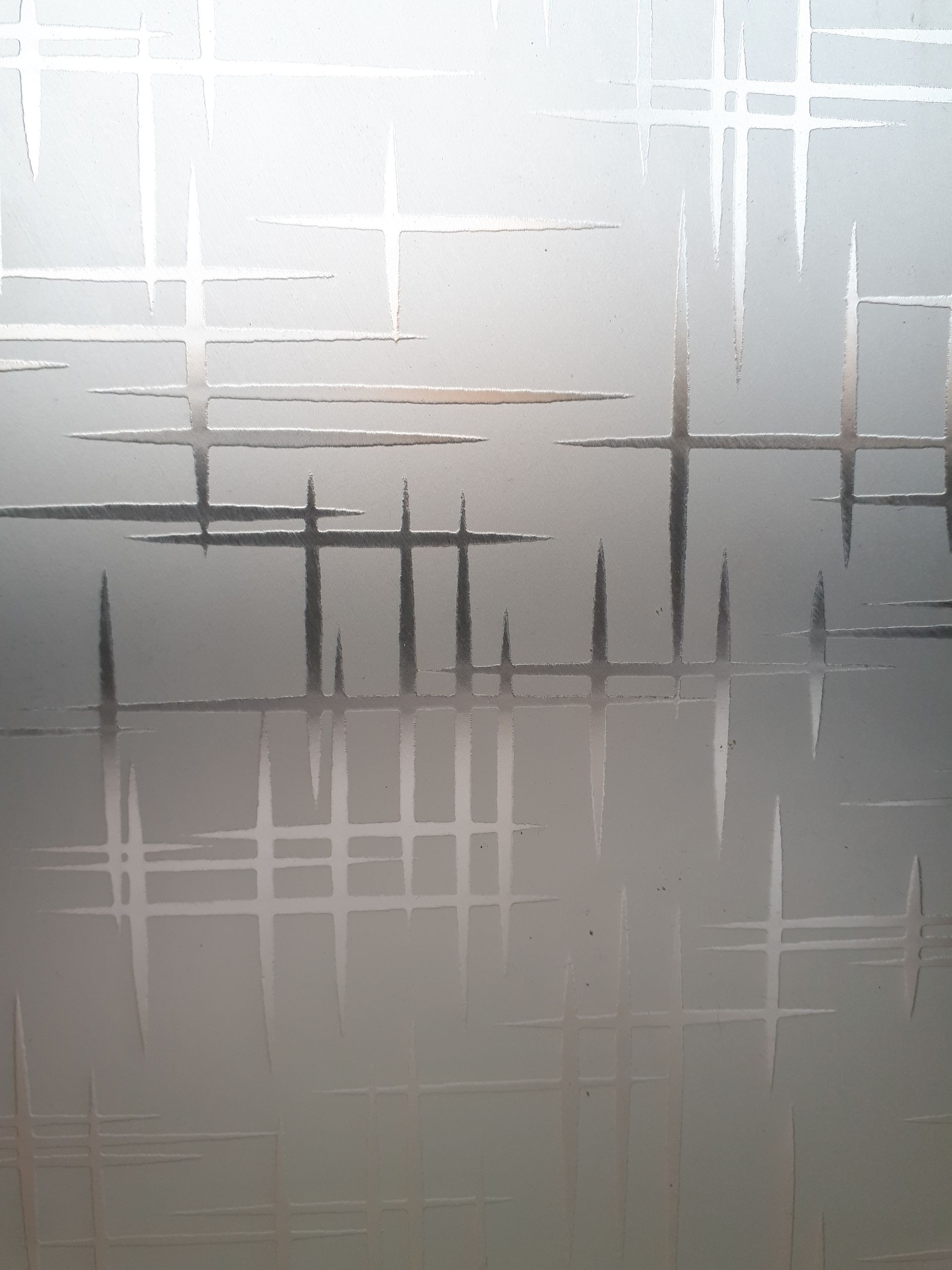 Abstract gray-and-white frosted glass with intersecting horizontal and vertical lines