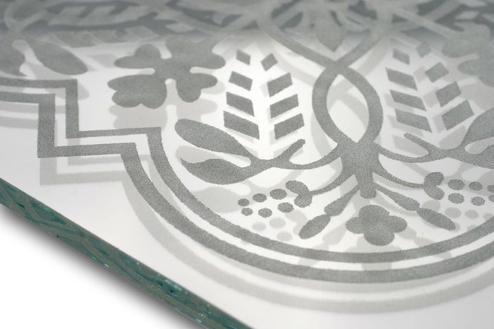 Close-up of a frosted glass panel with etched floral and geometric patterns