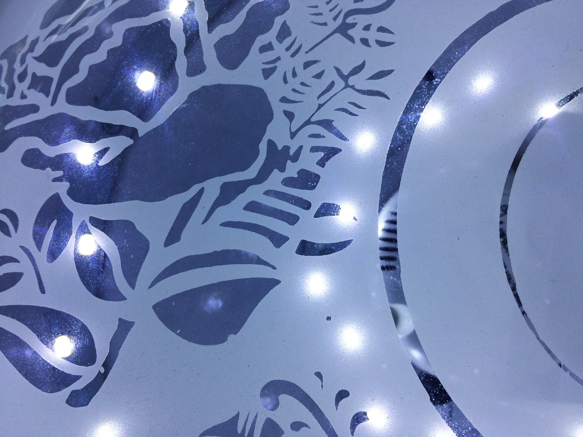 Blue and white decorative design with a stylized face and glowing dots on a patterned surface