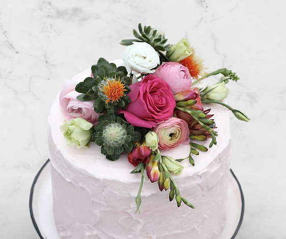 A pink cake with flowers on top of it