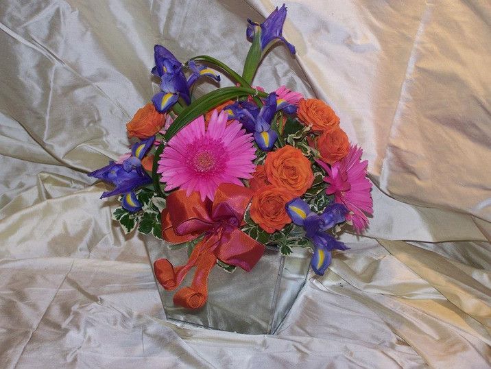 A glass vase filled with pink and orange flowers