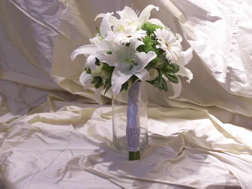 A bouquet of white and green flowers in a clear vase