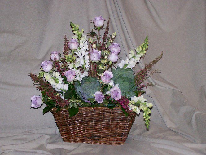 A wicker basket filled with purple and white flowers