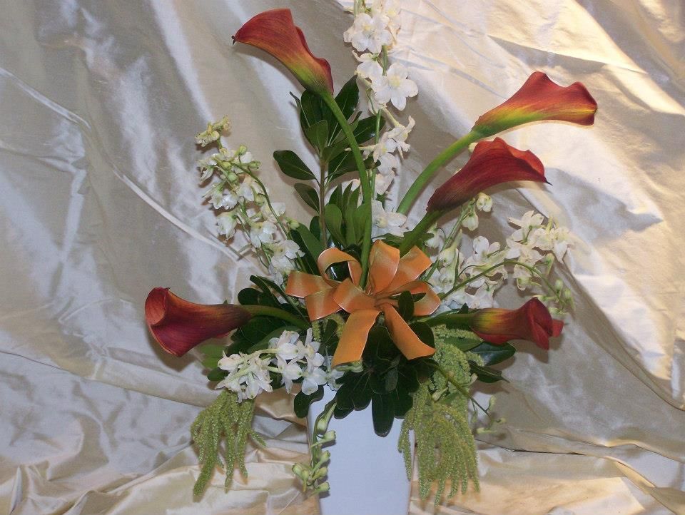 A vase filled with red flowers and white flowers