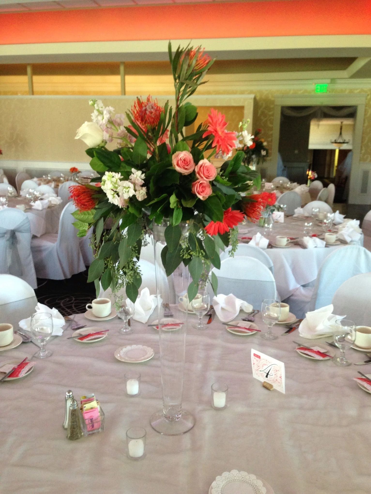 A tall vase filled with flowers is on a table.