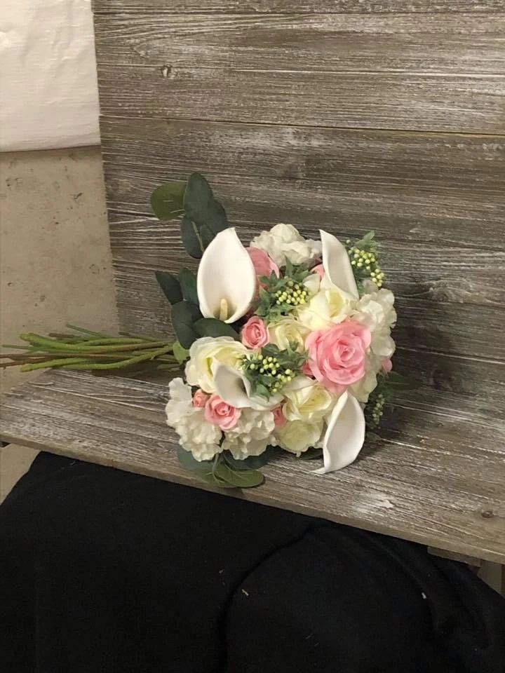 A bouquet of flowers is sitting on a wooden bench.