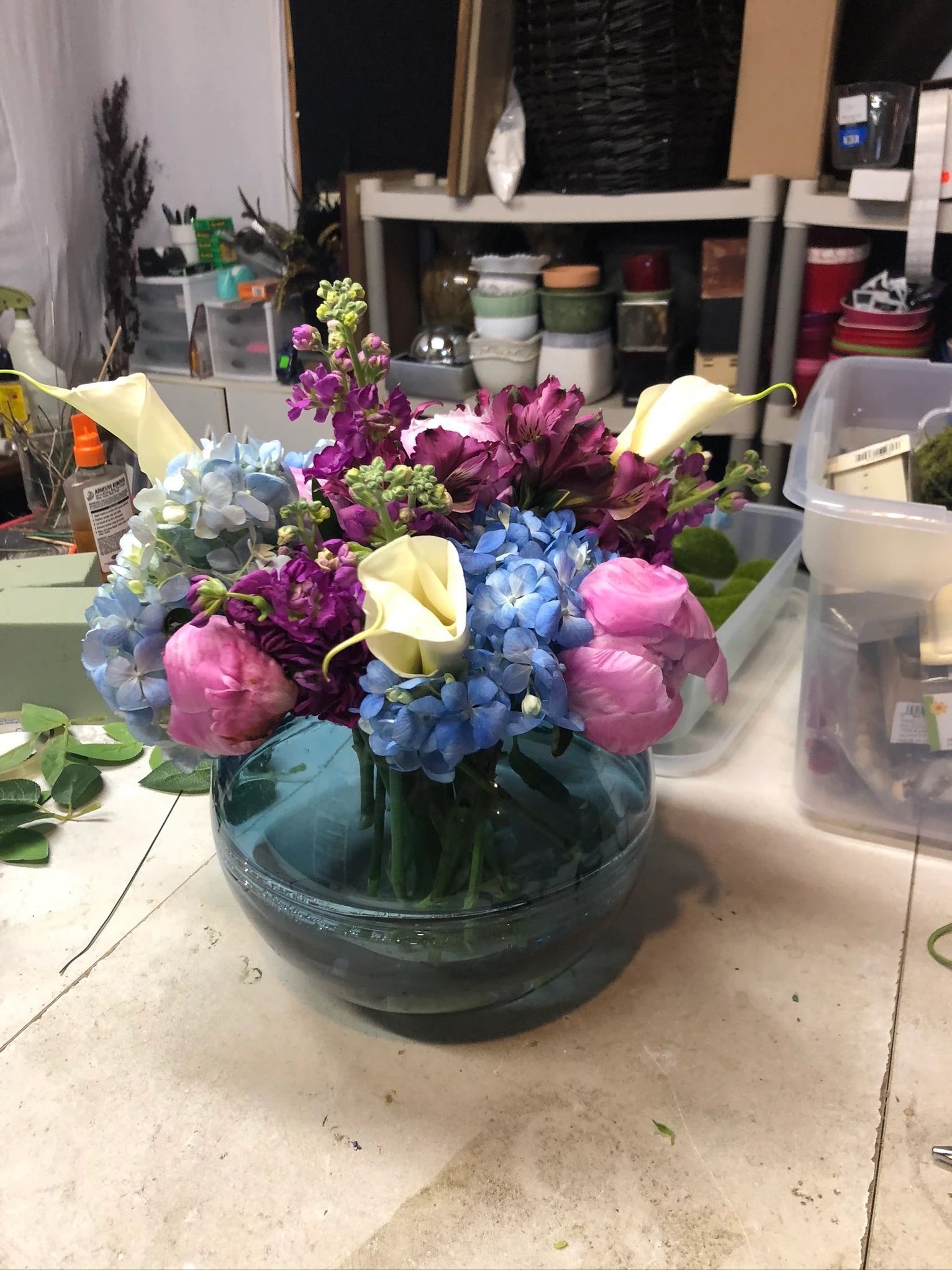 A vase filled with purple and blue flowers is sitting on a table.
