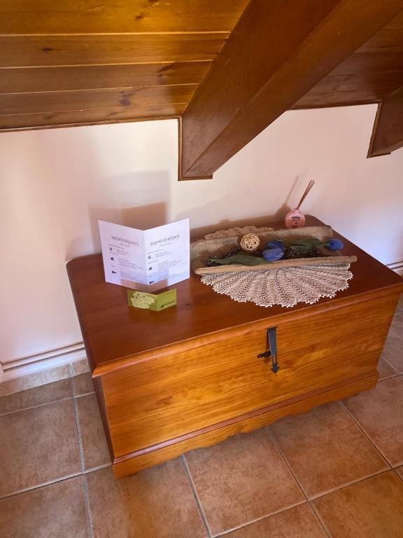 Cofre de fusta sota una escala amb decoracions, una targeta i un terra de rajoles ceràmiques.