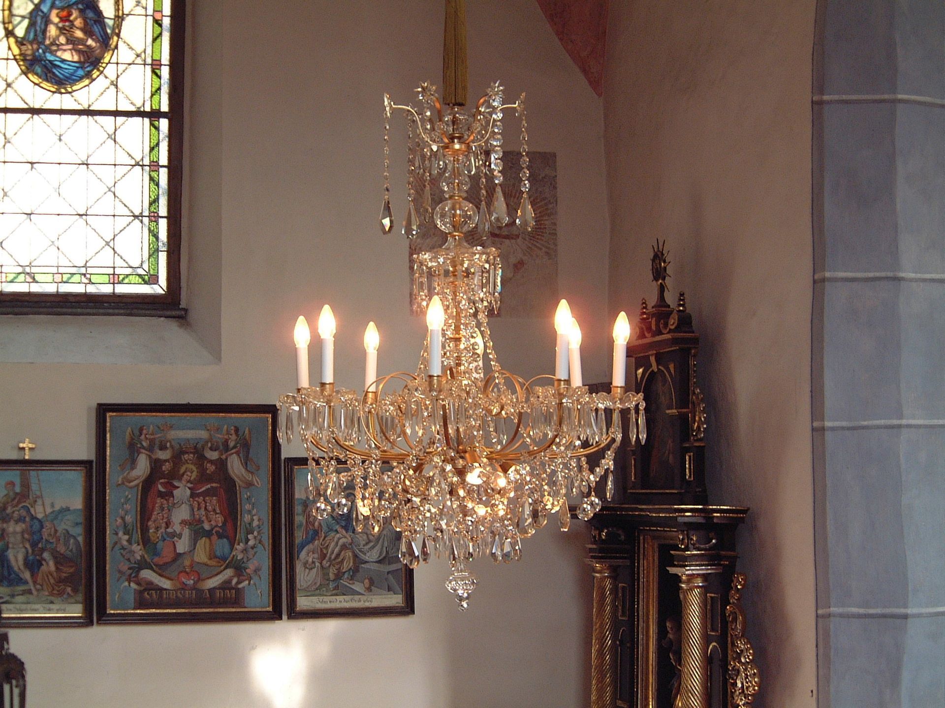 ein Kronleuchter mit vielen Kerzen hängt in einer Kirche