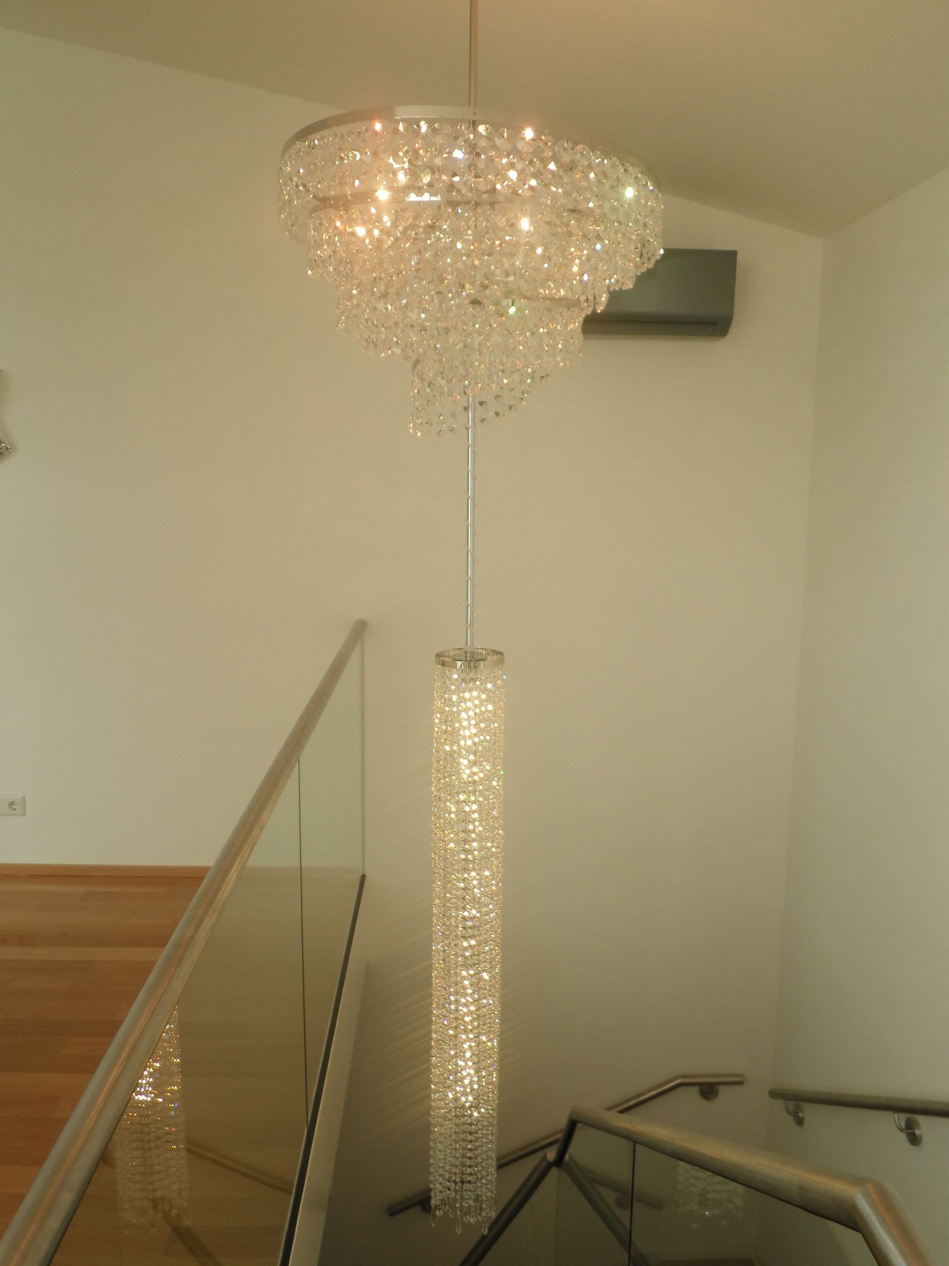 ein großer Kronleuchter hängt an einer Treppe