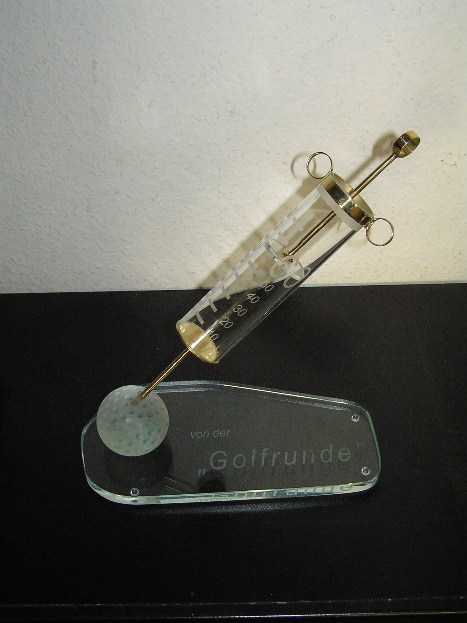 eine Modell einer Glasspritze steht auf einer Glasplatte