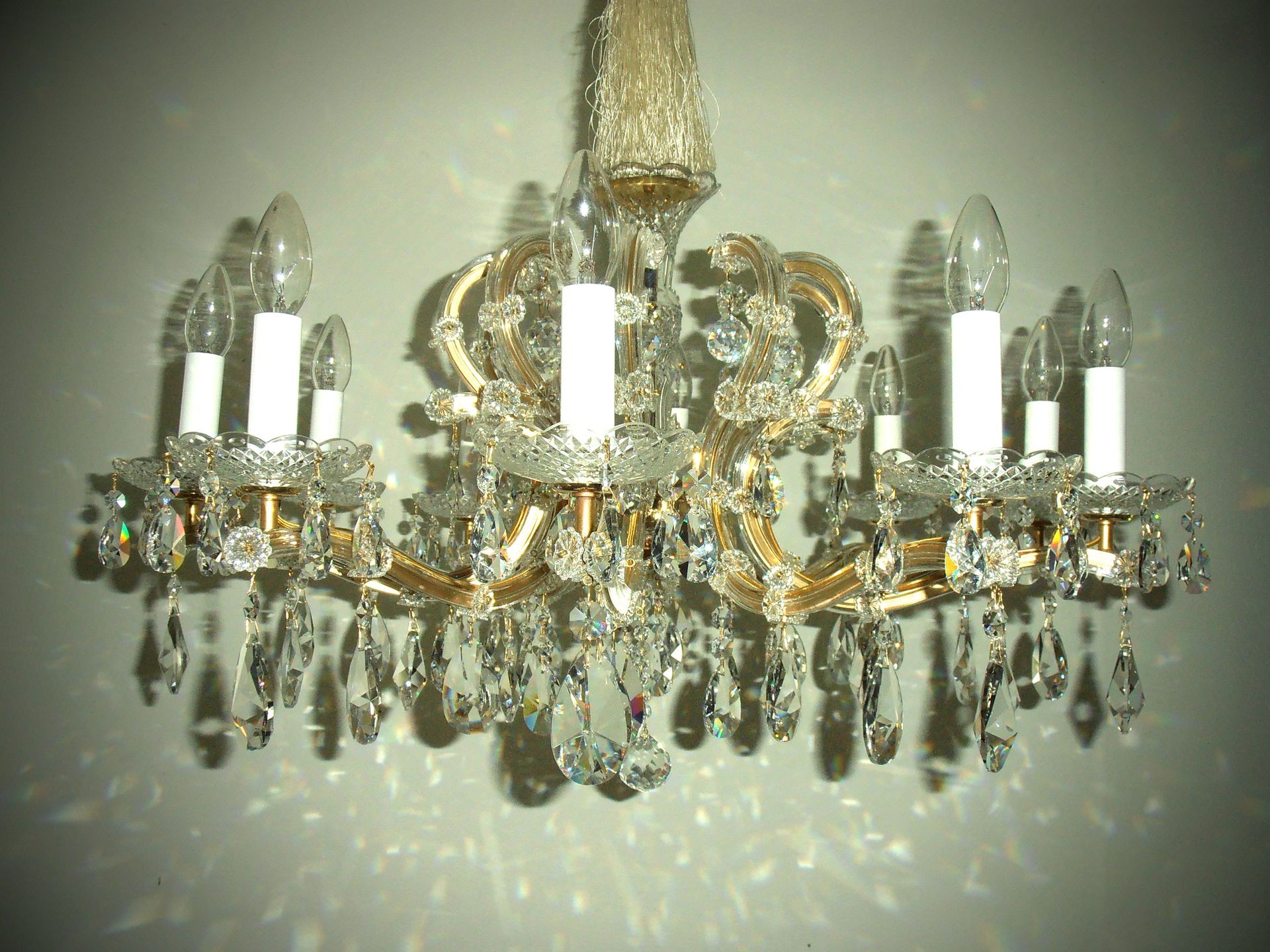 ein Kronleuchter mit vielen Kristallen und weißen Kerzen