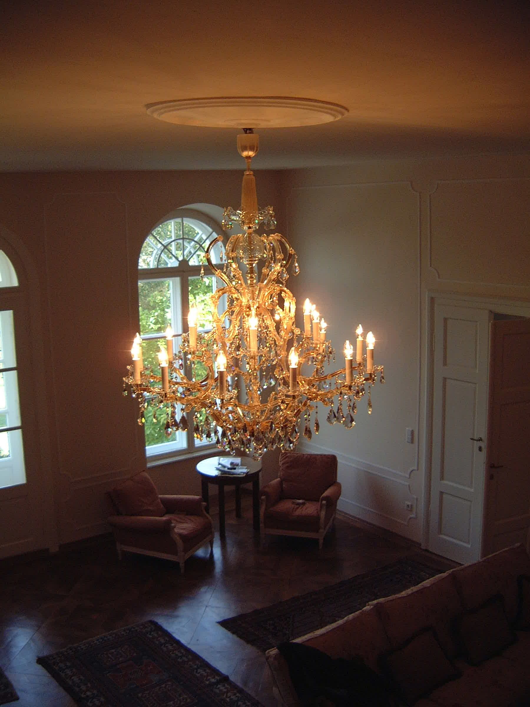 ein Wohnzimmer mit einem großen Kronleuchter , der von der Decke hängt