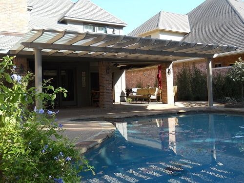A large swimming pool with a pergola over it